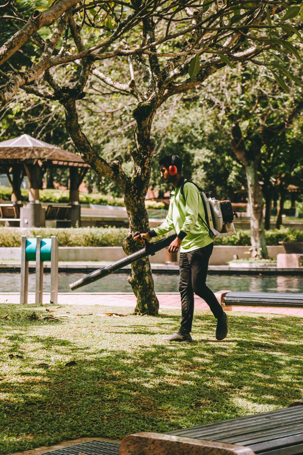 Two crew members clearing leaves from a lawn with blowers
