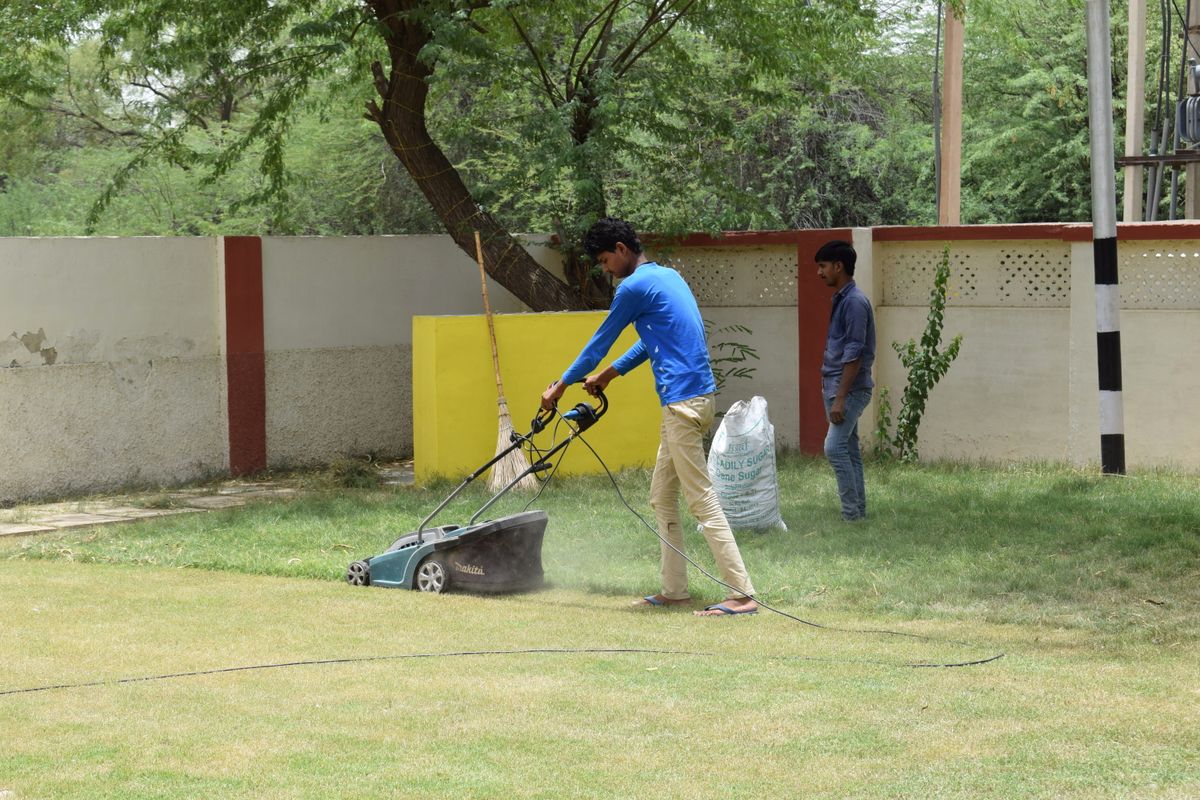 Two crew members working together on a lawn