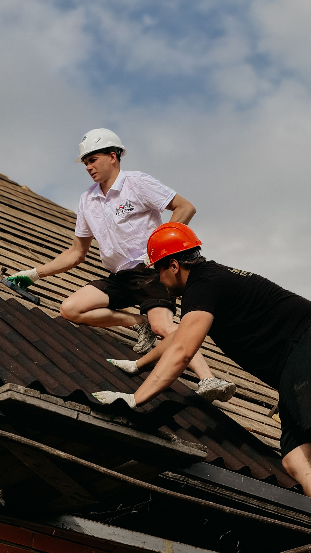 Two roofers working on a residential roof