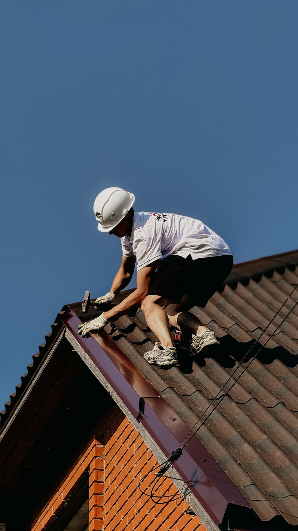 A roofer working on a section of a house roof